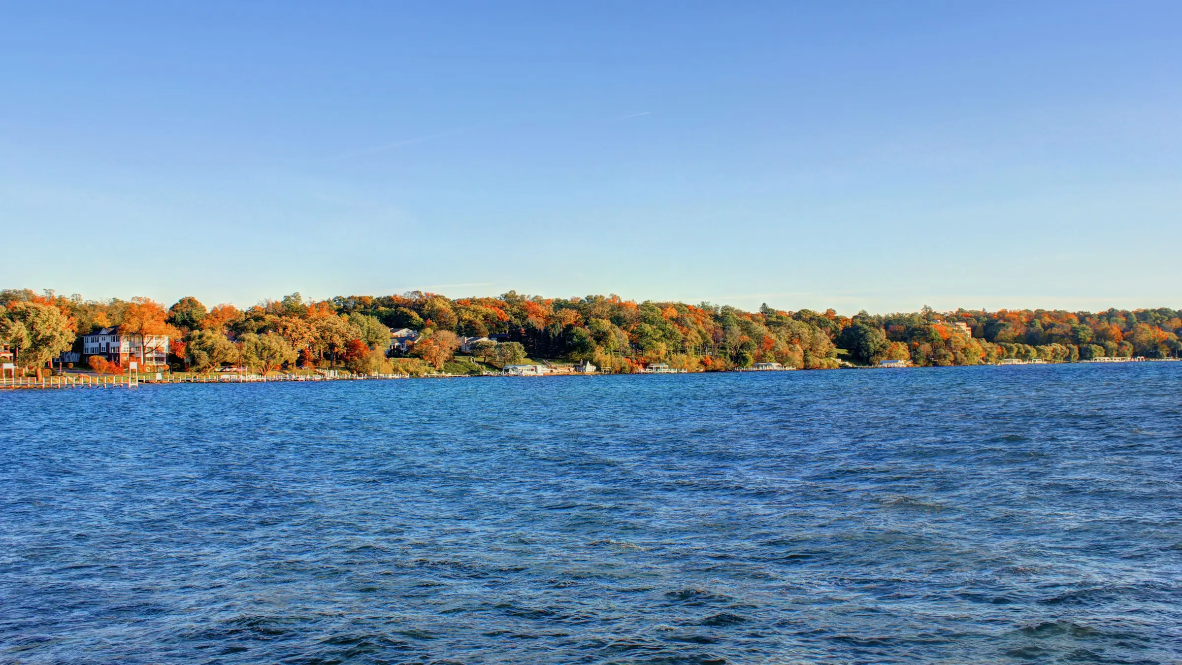 Geneva Lake in Lake Geneva, Wisconsin, with autumn trees and lakeside homes along the far shore