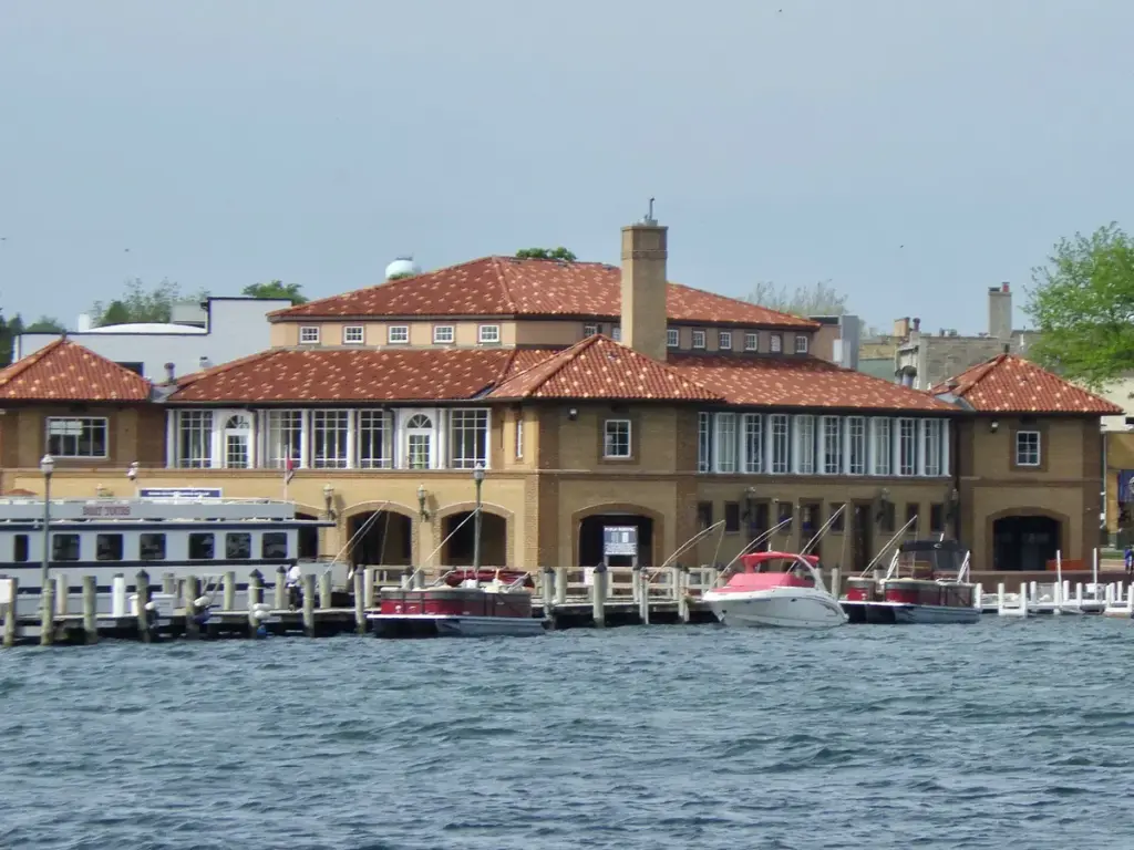 The Riviera, a tile-roofed 1930s building on the Lake Geneva waterfront, with boats at its docks