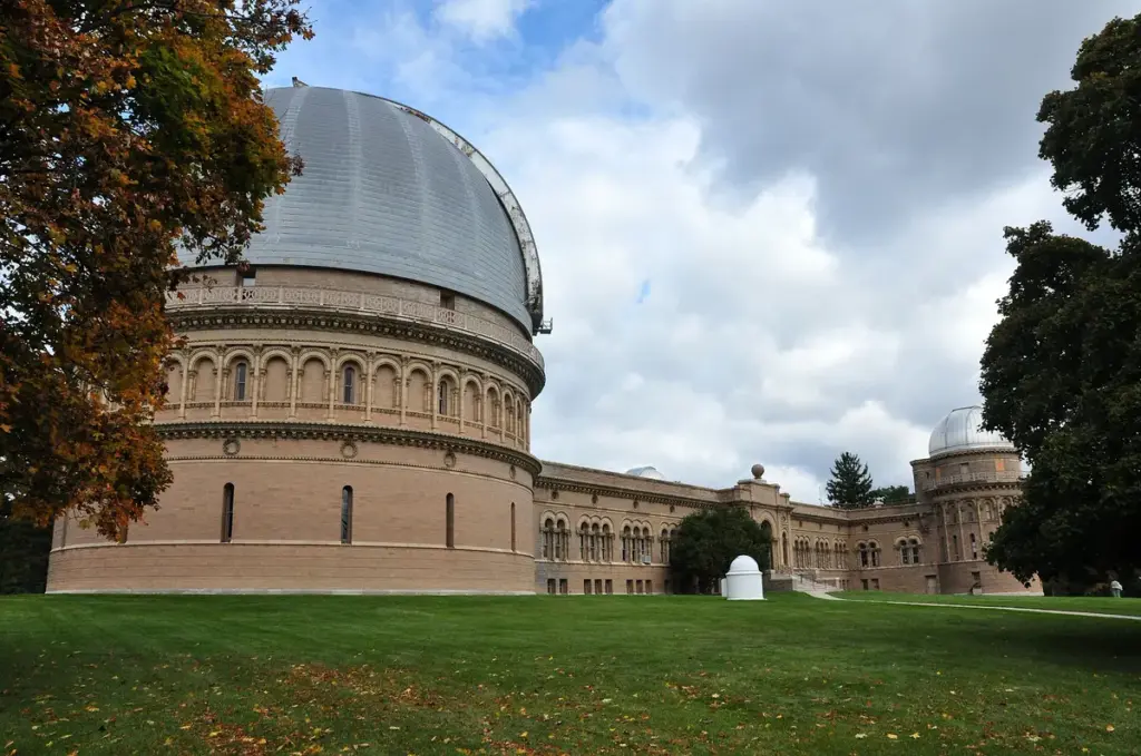 Yerkes Observatory's large dome and stone buildings on a lawn in autumn
